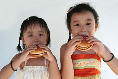Ethnic children eating burgers